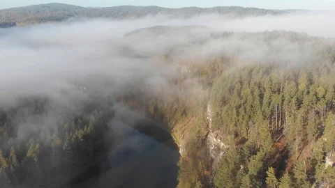 Slow aerial flight backwards over a gentle mountain river, pine forest, clouds. Stock Footage 101617592