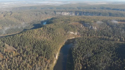 Slow aerial flight backwards over a gentle mountain river, pine forest, clouds. Stock Footage 101630871