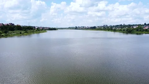 Slow aerial flight over a large lake in a park area of the city on a sunny day Stock Footage 137949435