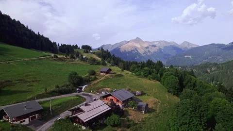 Slow aerial forward movement showing Alpine mountain chalets in summer Stock Footage 317816407