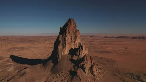 Slow aerial orbit of dramatic volcanic remnant in the desert of Monument Valley Stock Footage 147965579