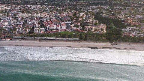 Slow Aerial Pullaway of Train riding along California Coastline Stock Footage 125709848