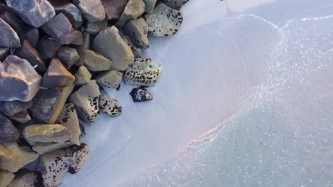 A slow aerial pullback of gentle waves on a rocky beach The Essence of Tran.. 스톡 동영상 316883634