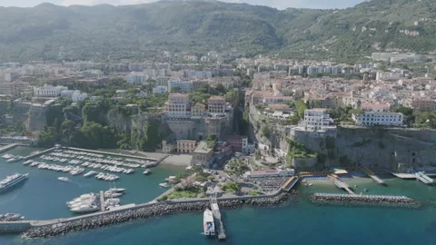 Slow aerial push towards the cliffs of Sorrento with the sea and harbor in Stock Footage 235418215