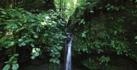 Slow and short aerial pulling back from Emerald Pool waterfall Stock-Footage 69952133