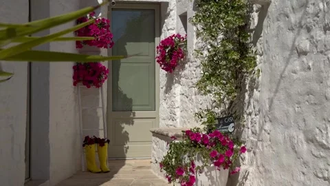 Slow Approach to Flower Decorated Trullo Door in Alberobello, Italy 스톡 동영상 337800876