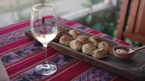 Slow arc reveal of wine bread delicatessen and dipping sauce on rustic table Stock Footage 336669338