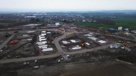 Slow arcing shot of housing plots on a construction site during a housing Stock Footage 269132798