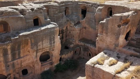 Slow Ascending Drone Shot Approaching Ancient Cave Rooms in Dara Ancient Cit Stock Footage 334797694