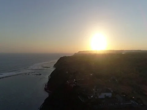 Slow ascent toward sunset over beach, cliffs, and ocean in Bali, Indonesia. Stock Footage 80177156