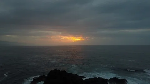 Slow backward flight above stormy ocean towards beautiful colourful sunset Stock Footage 114897327