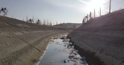 Slow backwards moving dolly shot of drainage or sewage water canal Stock Footage 125783527