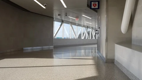 Slow backwards pan down empty hallway at ORD with one traveler Stock Footage 128670446