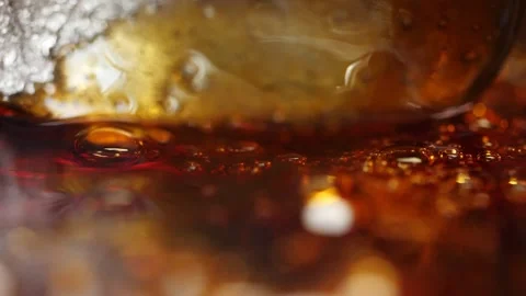 Slow-boiling caramelized sugar syrup is mixed with a spoon, macro shot. Stock Footage 130663102