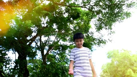 Slow boy walking in the park Stock Footage 79588778