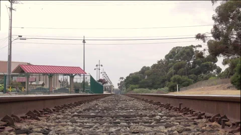 Slow camera dolly of train tracks near train station down the horizon with trees 스톡 동영상 60144884