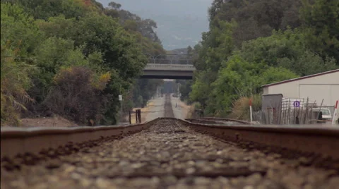 Slow camera dolly of train tracks down the horizon with trees 스톡 동영상 60149793