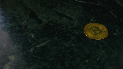 Slow camera move past bitcoin on dark marble surface Stock Footage 320926775