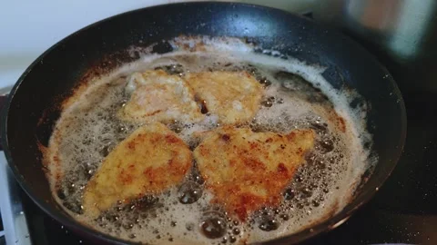 Slow camera movement abovepan with breaded schnitzels and plate of schnitzels Stock Footage 311774681
