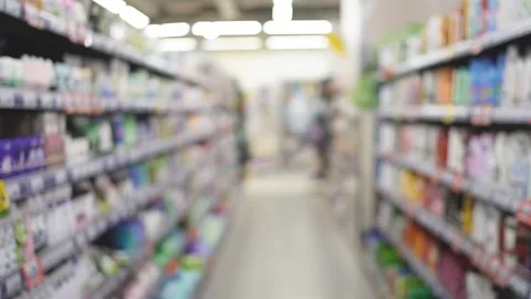 Slow camera movement between two shelves with goods in a supermarket Stock Footage 143086343
