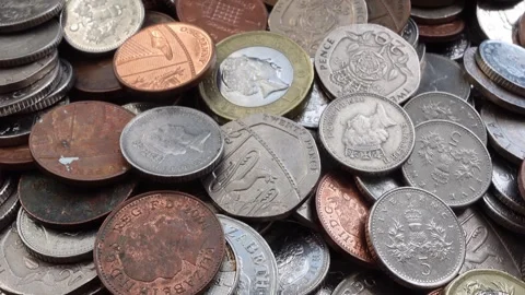 Slow camera movement over pile of United Kingdom coins seamless loop 動画素材 335090958