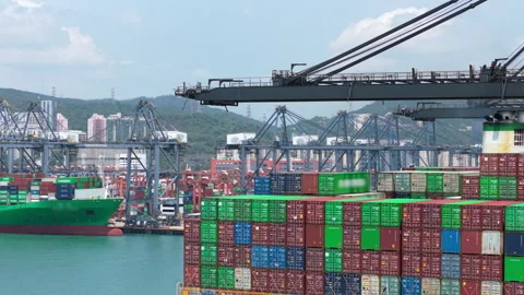 Slow camera pan across colorful stacked shipping containers and large gantry Stock Footage 346889875