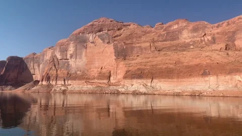 Slow camera pan across crystal clear blue water and striking red rock canyon 스톡 동영상 347732125