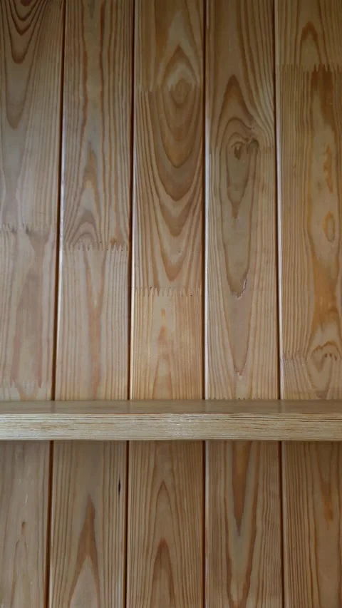 Slow camera pan left across rustic wooden wall with shelf Stock Footage 345449222