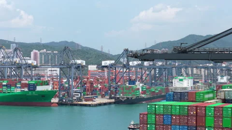 Slow camera pan over a busy container terminal with gantry cranes, moored cargo Stock Footage 347868517
