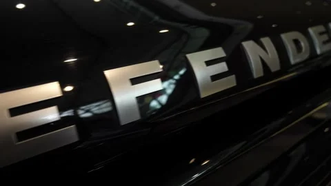 Slow camera panning from left over black car body with large DEFENDER logo Stock Footage 274320000