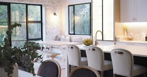 Slow camera is panning from left window, revealing kitchen island and stools to Stock Footage 344668890