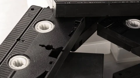 Slow camera rotation across retro VHS video tapes Stock Footage 105679783