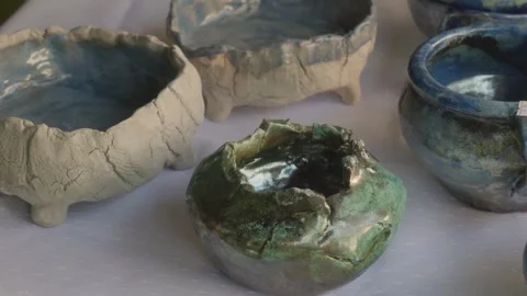 Slow Camera Slide over Handmade Fired Clay Products on Table Stock Footage 317939642