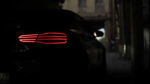 Slow car movement through a dark courtyard with beautiful taillights. Stock Footage 150107018