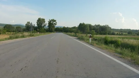 A slow car or motorcycle ride on a winding country road. POV shot Stock Footage 230892156