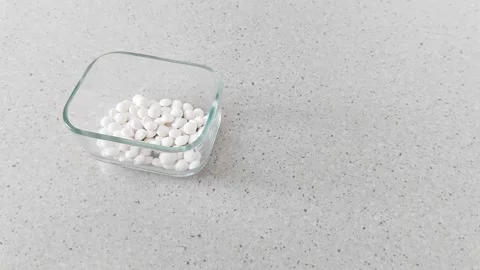 Slow Cascade: Precision in Motion as White Pills Fill the Vessel Video stock 316026747