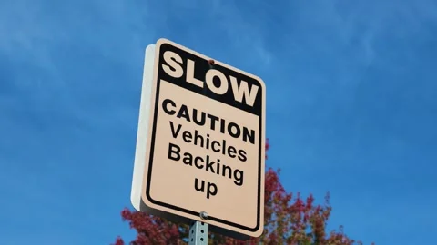 Slow Caution Vehicles Backing Up Traffic Warning Sign with Autumn Trees Vídeo Stock 347123022