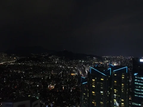 Slow climb and push over tall city buildings in Seoul revealing sprawling city. Stock Footage 78122276