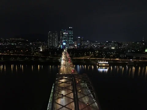 Slow climbing shot: Han River with a bridge, night traffic, and city in Seoul. Stock Footage 78105547