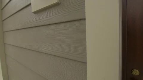 Slow Close-up Down and Up Tilt of Tan Siding Stock Footage 100899569