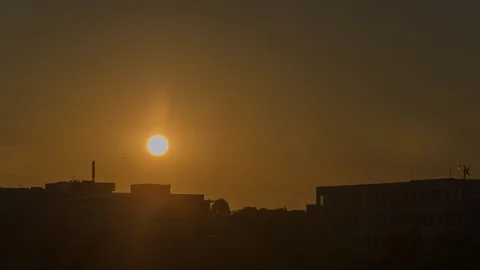 Slow close-up sunset behind urban buildings 스톡 동영상 99536127