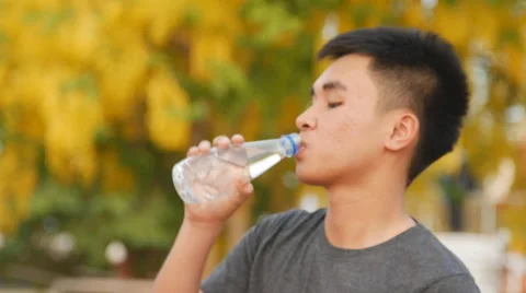 Slow Close-up of a young man drinking water from a bottle outside Stock Footage 62011939