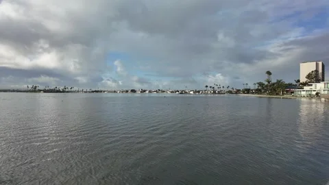 Slow clouds over bay with tall hotel 스톡 동영상 279050040