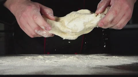 SLOW: Cook throws up and kneads a dough on a table Stock Footage 62900530