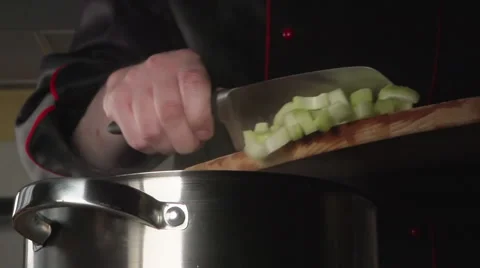 SLOW: Cook throws a sliced celery into a steel pan Vídeo Stock 63626231