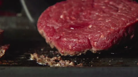 SLOW: Cook turns over a blood beefsteak on grill Video stock 63393085