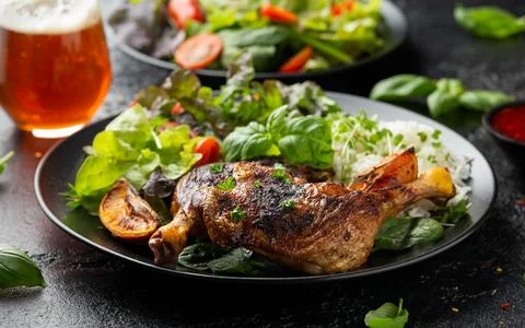Slow cooked aromatic duck legs with basmati rice and side salad served with Stock Photos