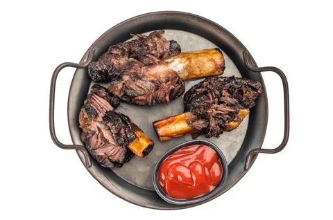 Slow cooked beef short ribs with bone and BBQ sauce served in pan. Tender b.. Stock Photos