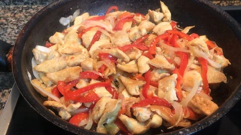 Slow cooked chicken strips between bell peppers and sliced onions Stock Footage 127914279