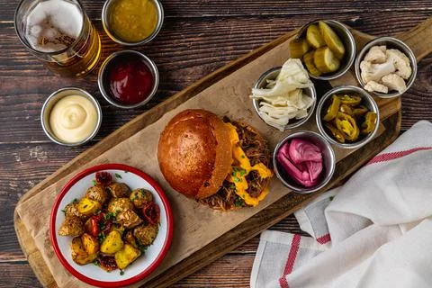 Slow cooked pulled rib beef burger with melted cheese and sides Stock Photos